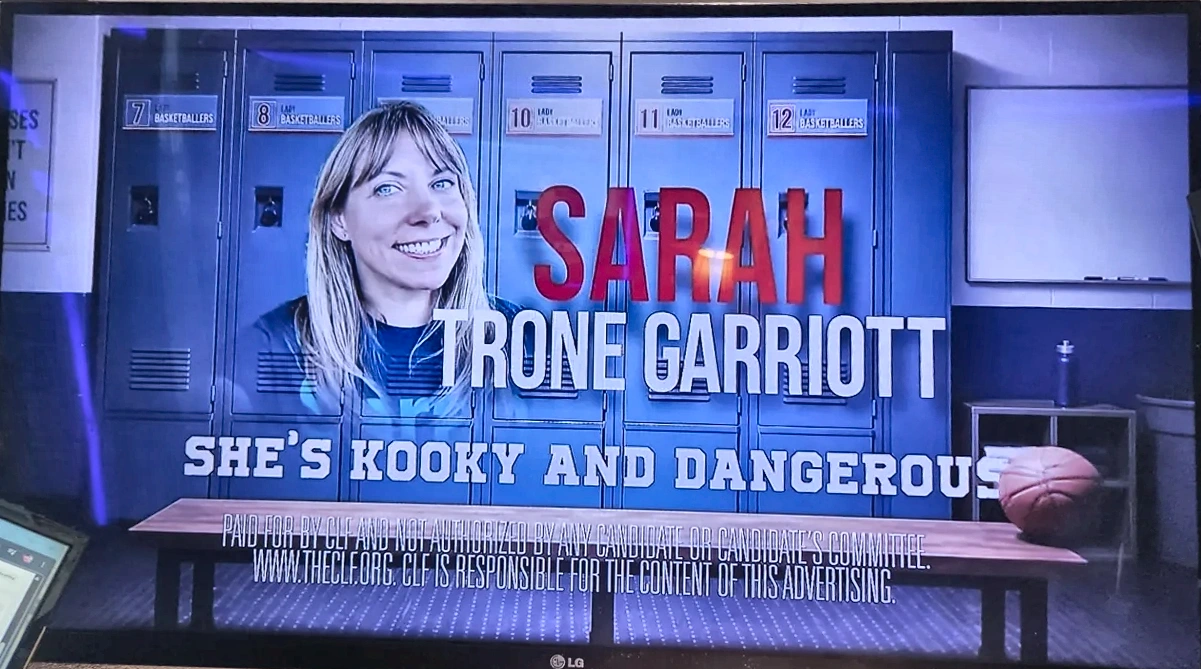 Television frame from a CLF ad against Sarah Trone Garriott reading she's kooky and dangerous